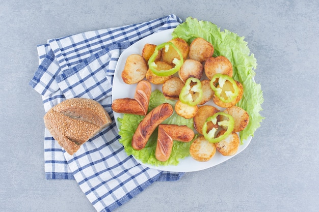 Pommes de terre sautées avec des saucisses, coupées en tranches et frites dans l'huile, i.