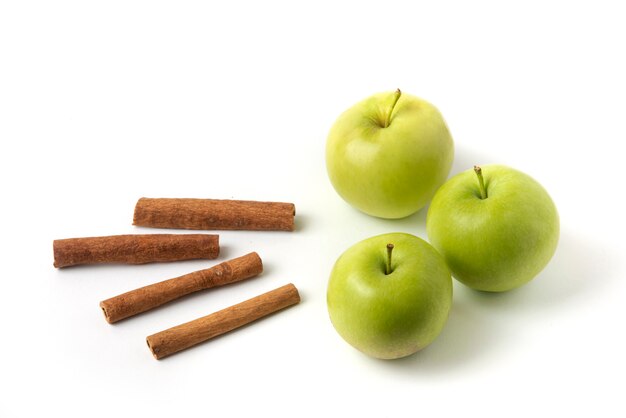 Pommes vertes et cannelles isolés sur blanc