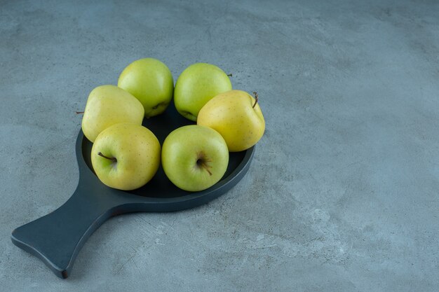 Pommes vertes sur une casserole, sur le fond de marbre. photo de haute qualité