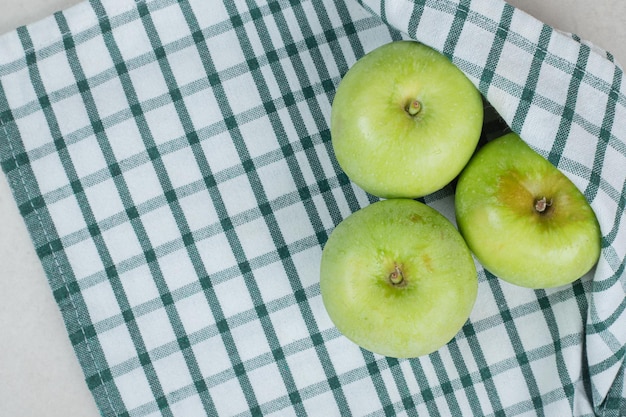 Pommes vertes entières sur nappe à rayures