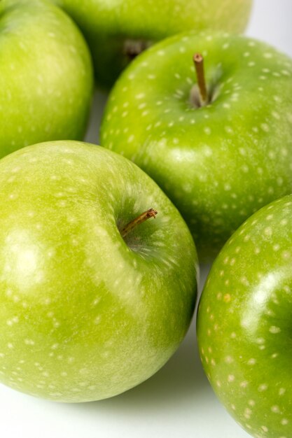 Pommes vertes entières parfaitement formées mûres juteuses mûres sur fond blanc