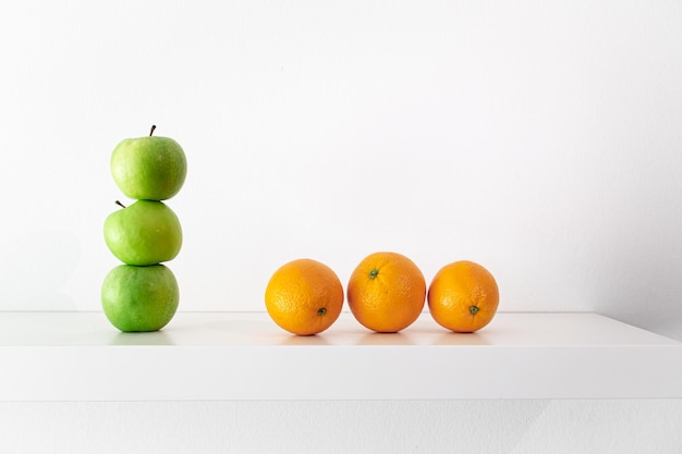 Pommes vertes et oranges sur fond blanc gros plan