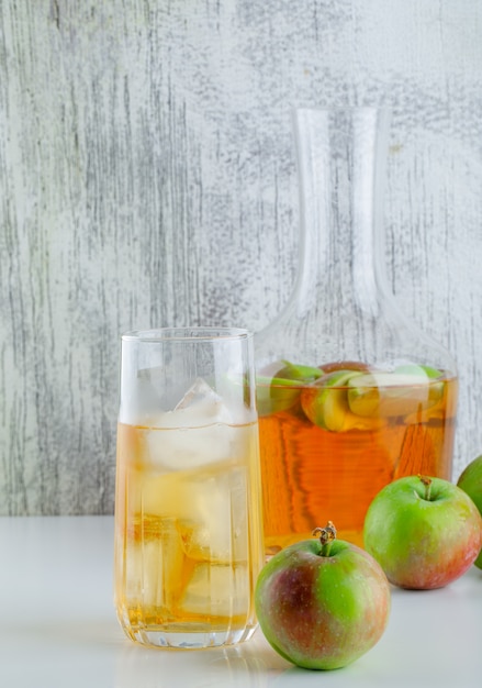 Photo gratuite pommes avec vue de côté de boissons sur blanc et grungy