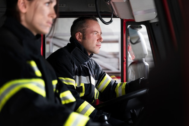 Pompier masculin et féminin à la station en camion de pompiers