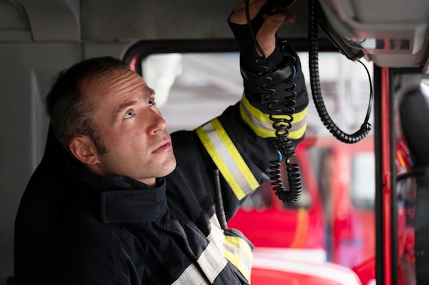 Pompier masculin à la station à l'intérieur du camion de pompiers