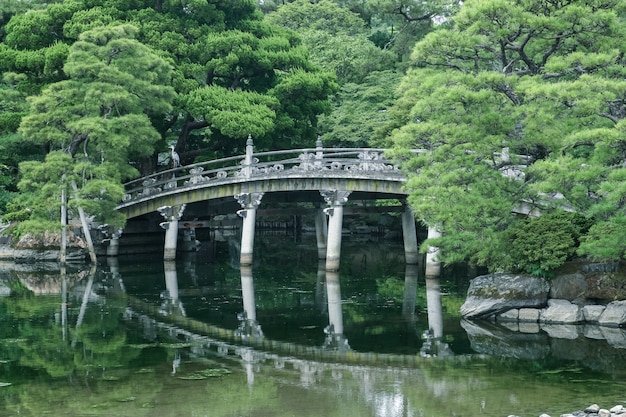 Photo gratuite pont de pierre sur l'étang dans la cour