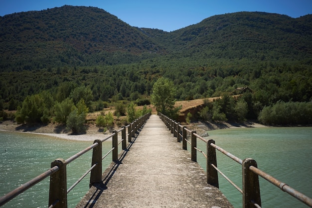 Photo gratuite pont piétonnier en béton sur une baie entre les collines verdoyantes