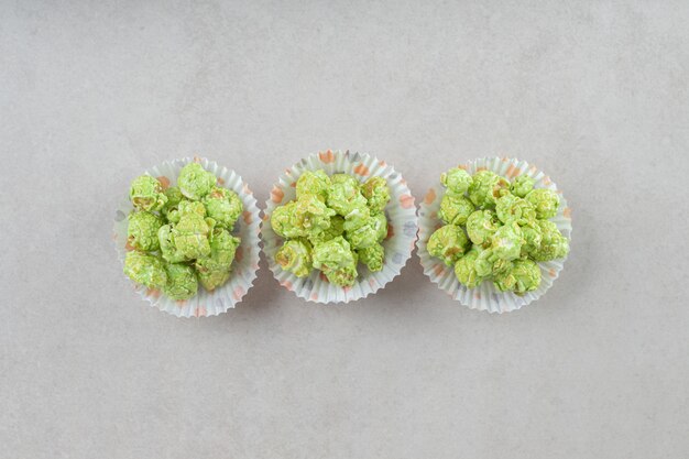 Photo gratuite pop-corn confit vert fileld en trois cas de galettes sur le marbre.