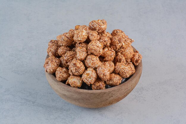 Pop-corn enrobé de bonbons bruns dans un bol sur une surface en marbre