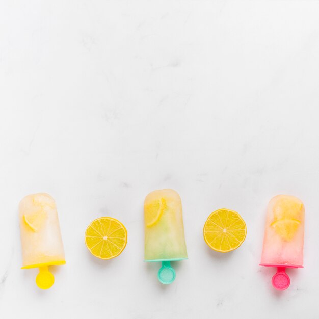 Popsicle tranché au citron et glace avec agrumes sur des bâtons colorés