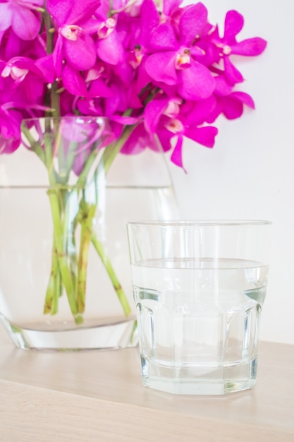 por fleurs et un verre d&#39;eau à proximité