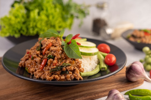 Porc haché épicé et riz sur une plaque noire.