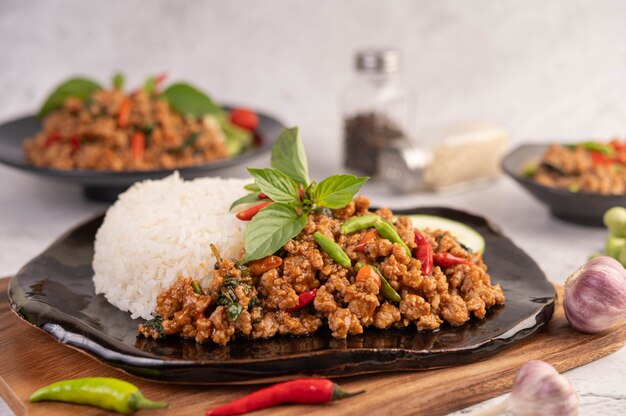 Porc haché épicé et riz sur une plaque noire.