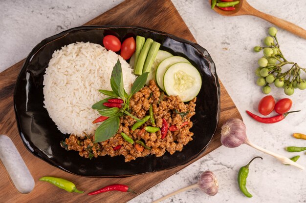 Porc haché épicé et riz sur une plaque noire.