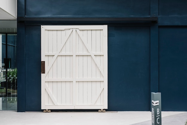 Porte blanche en bois sur un mur de bâtiment bleu