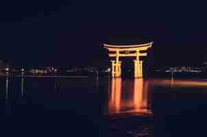 Photo gratuite porte torii flottante d'itsukushima illuminée la nuit, miyajimacho, japon