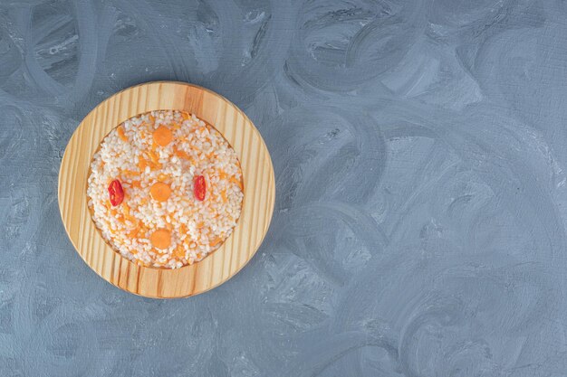 Portion de Pilaf sur un plateau en bois sur table en marbre.