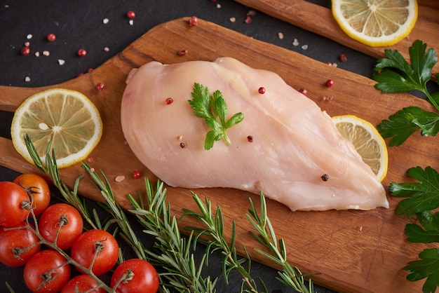 portions de viande de poulet fraîche pour la cuisson et le barbecue avec assaisonnement frais. Cuisse de poulet cru cru sur une planche à découper.