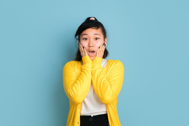 Portrait d'adolescent asiatique isolé sur fond bleu studio