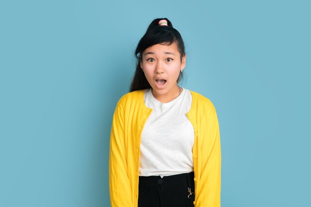 Portrait d'adolescent asiatique isolé sur fond bleu studio