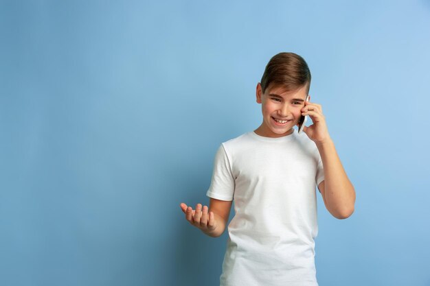 Portrait de l'adolescent caucasien isolé sur bleu