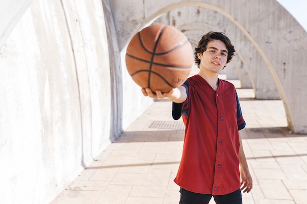 Photo gratuite portrait d'un adolescent montrant le basketball