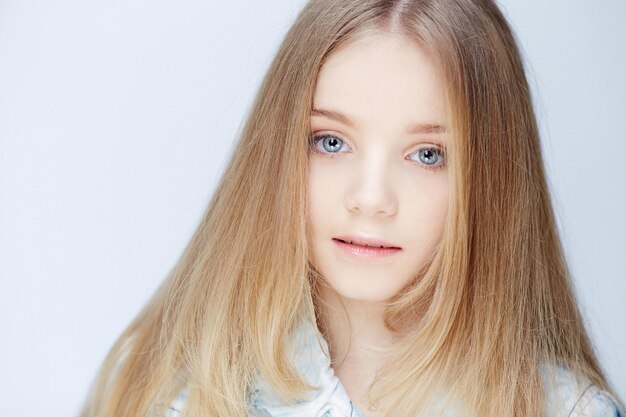 Portrait d'une adolescente aux longs cheveux blonds et aux yeux bleus.