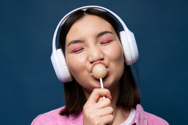Portrait d'une adolescente écoutant de la musique et léchant une sucette