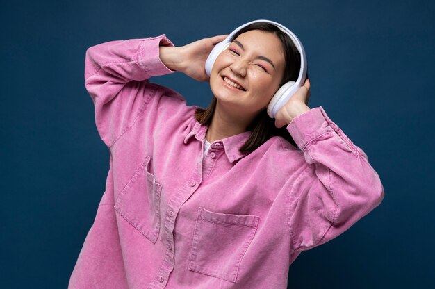 Portrait d'une adolescente écoutant de la musique et souriant