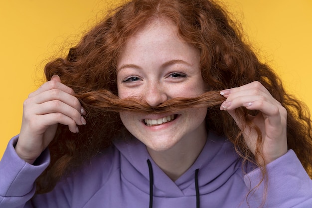 Portrait d'adolescente montrant une fausse moustache