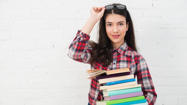 Portrait d&#39;adolescente avec une pile de livres