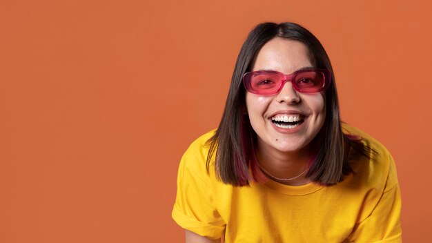 Portrait d'une adolescente portant des lunettes de soleil et souriant