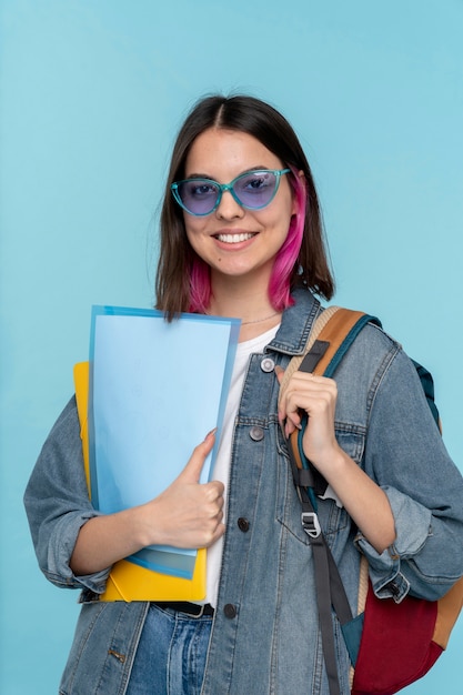 Portrait d'une adolescente portant des lunettes et tenant son sac à dos