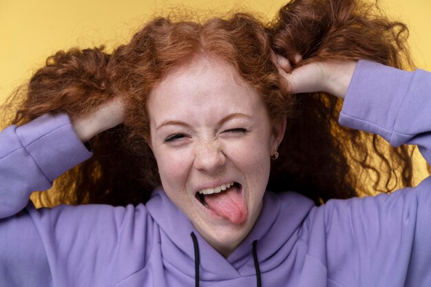 Portrait d'une adolescente qui a l'air heureuse et tire la langue