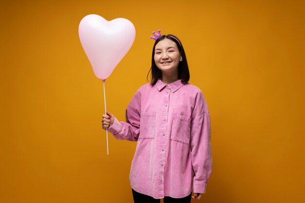 Portrait d'une adolescente tenant un ballon en forme de coeur