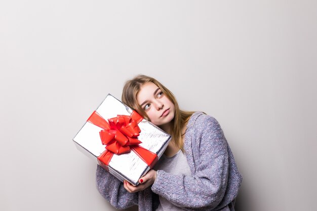 Portrait d'adolescente tenant présent et écouter à l'intérieur de la boîte isolée