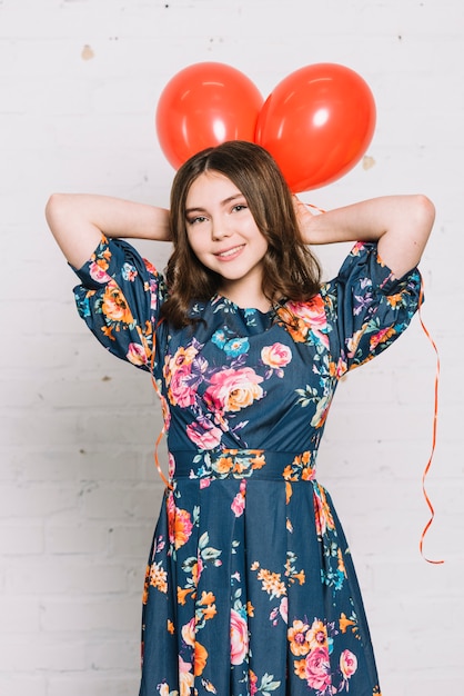 Photo gratuite portrait, adolescente, tenue, rouges, ballons, dessus, tête