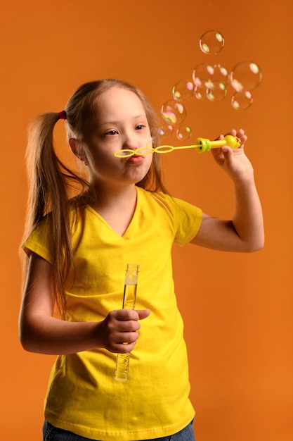 Portrait de l'adorable jeune fille soufflant des bulles