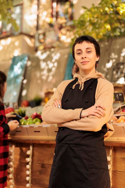 Portrait d'une agricultrice vendant des aliments sains sur le marché local, montrant des fruits et légumes frais de saison au marché des agriculteurs. Jeune vendeur se préparant à vendre des produits éco-biologiques.