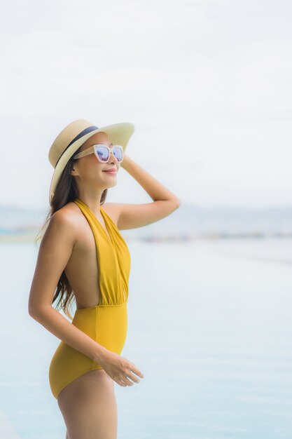 Portrait asiatique belle jeune femme heureuse sourire se détendre autour d'une piscine extérieure en vacances