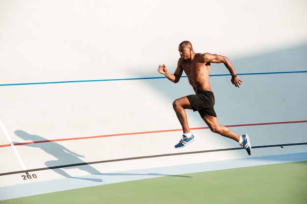 Portrait d'un athlète sportif à moitié nu sautant