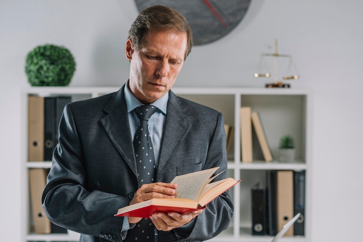 Photo gratuit portrait d&#39;un avocat mûr lisant un livre dans la salle d&#39;audience