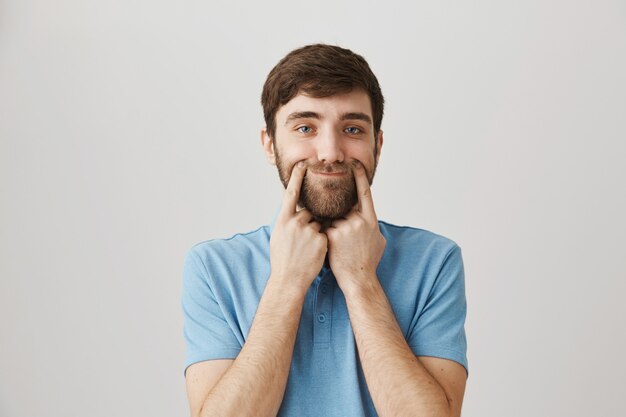 Portrait barbu d'un jeune homme avec tshirt bleu