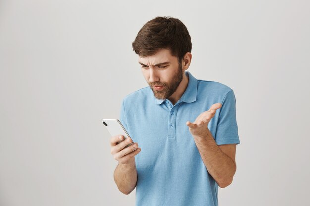 Portrait barbu d'un jeune homme avec tshirt bleu