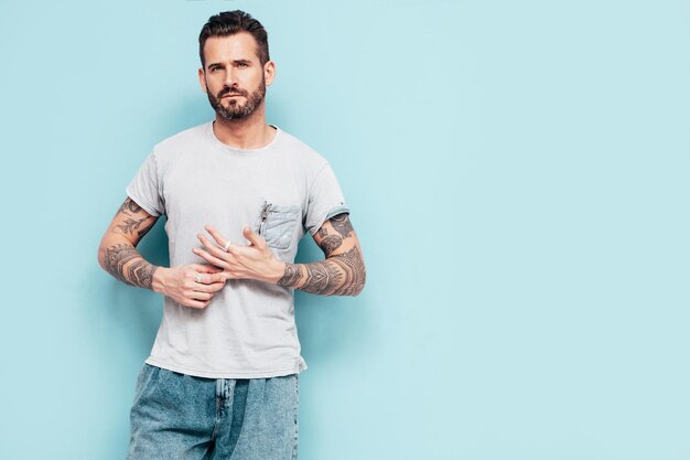 Portrait, de, beau, confiant, élégant, hipster, lambersexual, modèle, sexy, homme, habillé, dans, t-shirt, et, jeans, mode, mâle, isolé, sur, mur bleu, dans, studio