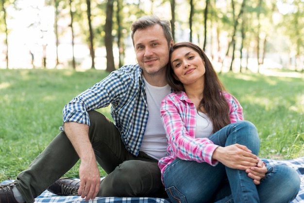 Portrait de beau couple d&#39;amoureux assis dans le parc