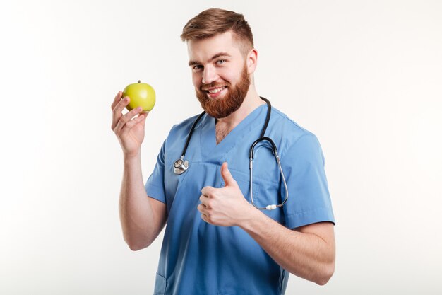 Portrait de beau docteur en manteau bleu regardant la caméra