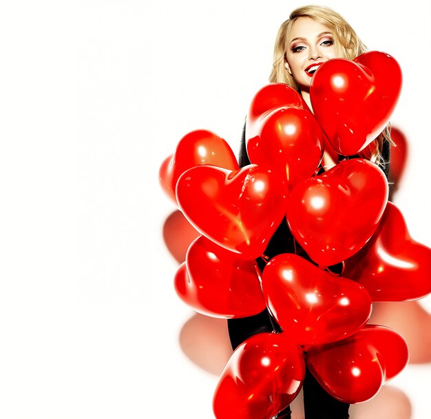 portrait, de, beau, heureux, doux, sourire, femme blonde, girl, tenue, dans, elle, mains, coeur rouge, ballons, dans, désinvolte, hipster noir, vêtements