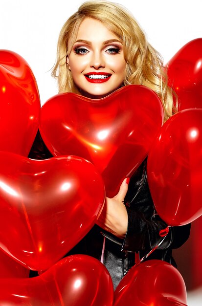 portrait, de, beau, heureux, doux, sourire, femme blonde, girl, tenue, dans, elle, mains, coeur rouge, ballons, dans, désinvolte, hipster noir, vêtements