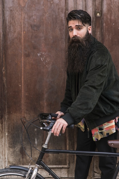 Portrait, beau, jeune, barbe longue, debout, bicyclette